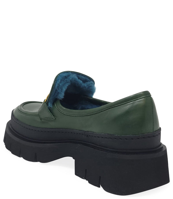 A leather loafer with an exaggerated lug sole and low-cut silhouette, featuring a wide strap with a geometric metal detail across the upper. Designed by Madison in Beverly Hills and handcrafted in Italy.