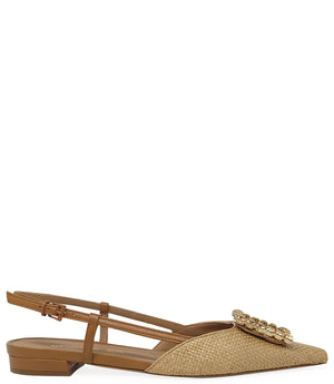 Pointed-toe slingback flat with low heel, adjustable ankle strap, and large decorative jewel embellishment on the toe. Features mixed material textures and an open heel design.