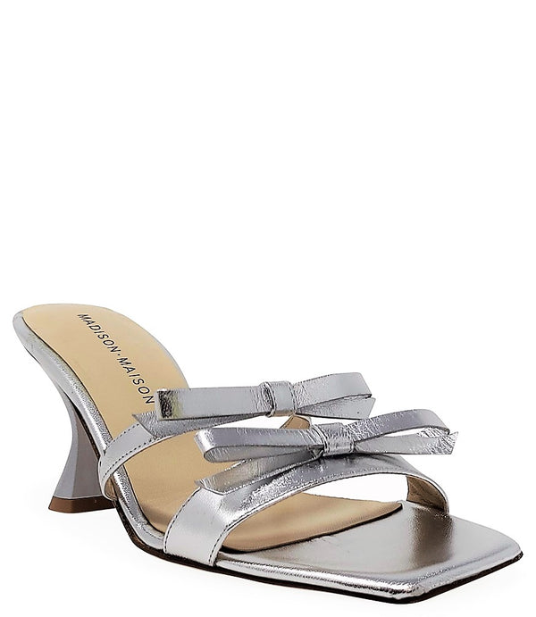 Women's open-toe sandal with a molded footbed, slip-on design, and decorative front strap featuring an embellished gemstone medallion. Crafted from smooth leather with a flat rubber sole. Designed in Italy by Madison Maison