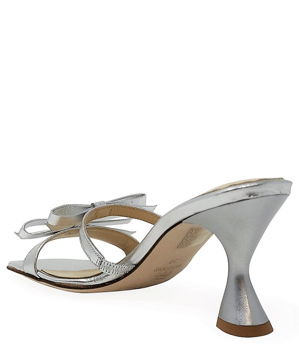 Women's open-toe sandal with a molded footbed, slip-on design, and decorative front strap featuring an embellished gemstone medallion. Crafted from smooth leather with a flat rubber sole. Designed in Italy by Madison Maison