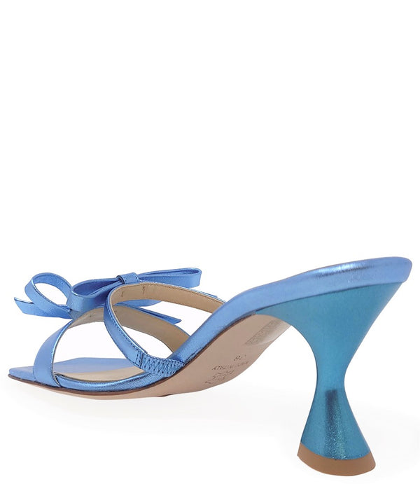 Women's open-toe sandal with a molded footbed, slip-on design, and decorative front strap featuring an embellished gemstone medallion. Crafted from smooth leather with a flat rubber sole. Designed in Italy by Madison Maison