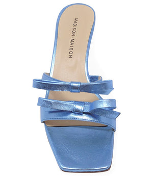 Women's open-toe sandal with a molded footbed, slip-on design, and decorative front strap featuring an embellished gemstone medallion. Crafted from smooth leather with a flat rubber sole. Designed in Italy by Madison Maison
