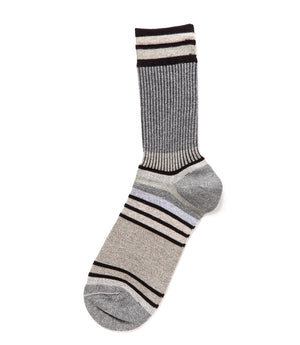 A mid-calf knit sock featuring a mix of textured panels, ribbed leg section, and bold horizontal stripes around the arch and cuff.