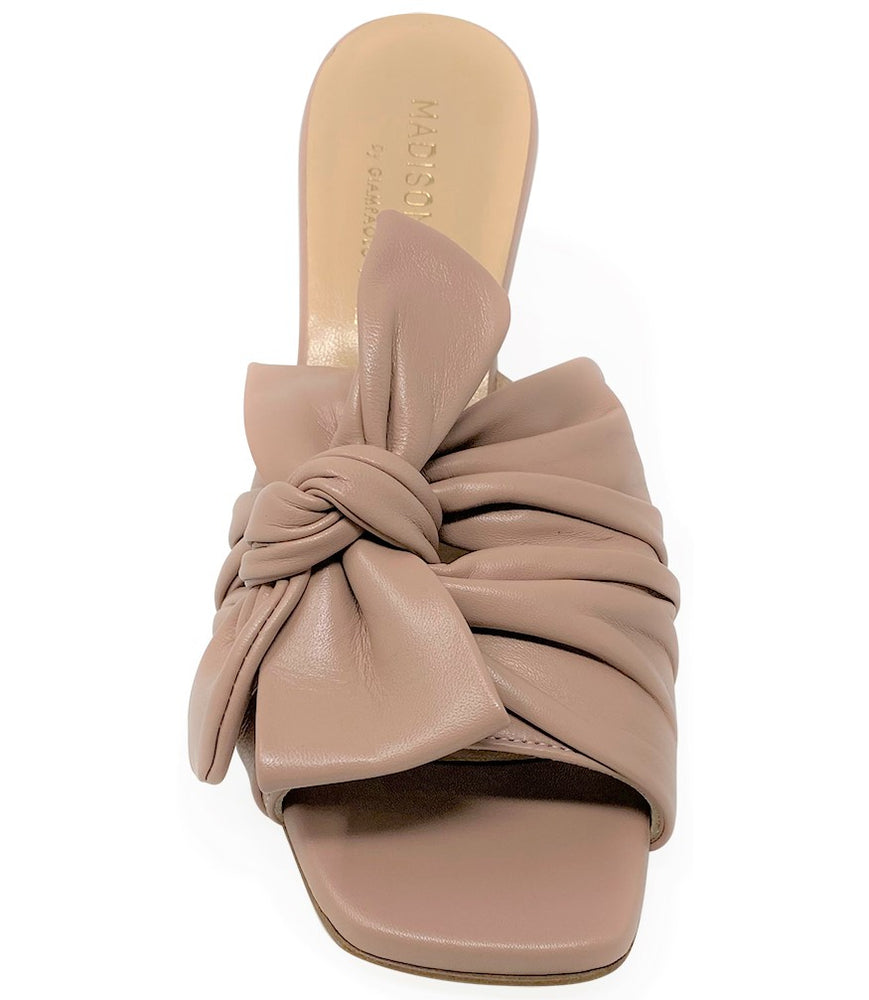 
                      
                        Open-toe mule handcrafted in Italy, featuring a metallic finish, wide vamp with a twisted bow detail, and a flared heel. Shown from multiple angles against a clean background
                      
                    