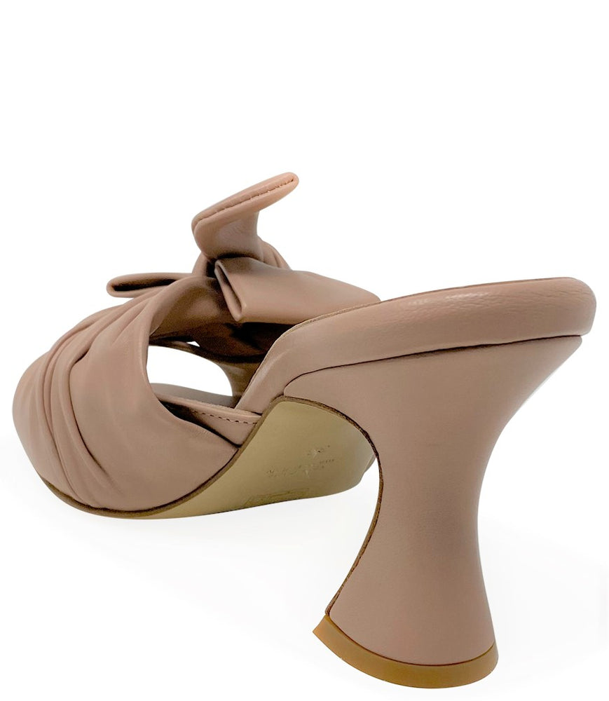 
                      
                        Open-toe mule handcrafted in Italy, featuring a metallic finish, wide vamp with a twisted bow detail, and a flared heel. Shown from multiple angles against a clean background
                      
                    