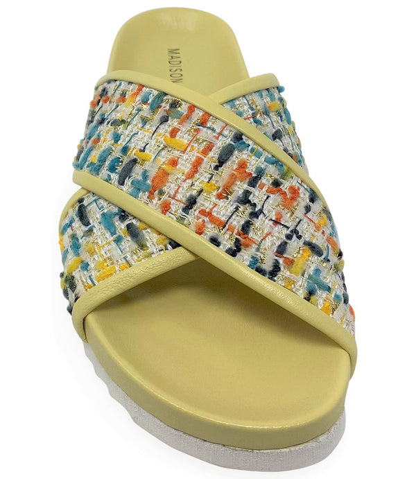 A handcrafted Italian open-toe flat sandal featuring a wide strap with a centered oval gemstone surrounded by circular studs, set on a molded footbed with a low platform sole."