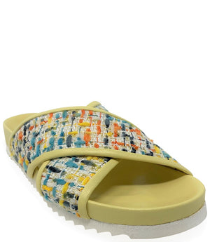 A handcrafted Italian open-toe flat sandal featuring a wide strap with a centered oval gemstone surrounded by circular studs, set on a molded footbed with a low platform sole."