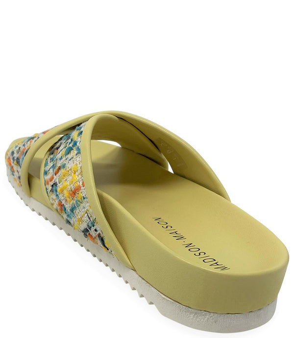 A handcrafted Italian open-toe flat sandal featuring a wide strap with a centered oval gemstone surrounded by circular studs, set on a molded footbed with a low platform sole."