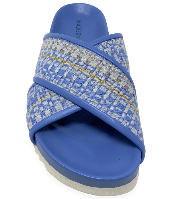 A handcrafted Italian open-toe flat sandal featuring a wide strap with a centered oval gemstone surrounded by circular studs, set on a molded footbed with a low platform sole."