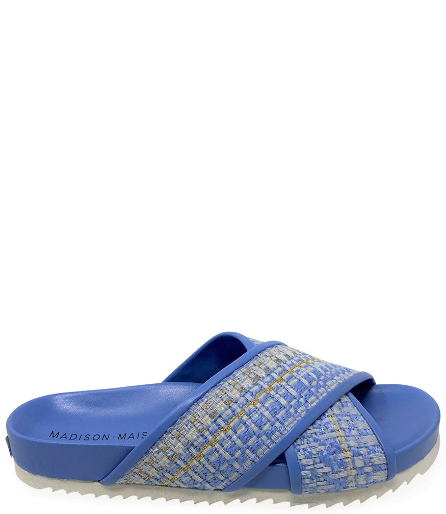 A handcrafted Italian open-toe flat sandal featuring a wide strap with a centered oval gemstone surrounded by circular studs, set on a molded footbed with a low platform sole."