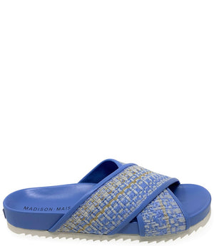 A handcrafted Italian open-toe flat sandal featuring a wide strap with a centered oval gemstone surrounded by circular studs, set on a molded footbed with a low platform sole."