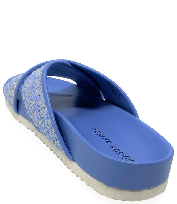 A handcrafted Italian open-toe flat sandal featuring a wide strap with a centered oval gemstone surrounded by circular studs, set on a molded footbed with a low platform sole."