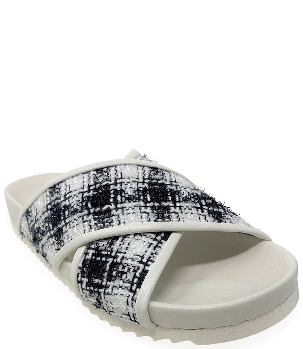 A handcrafted Italian open-toe flat sandal featuring a wide strap with a centered oval gemstone surrounded by circular studs, set on a molded footbed with a low platform sole."