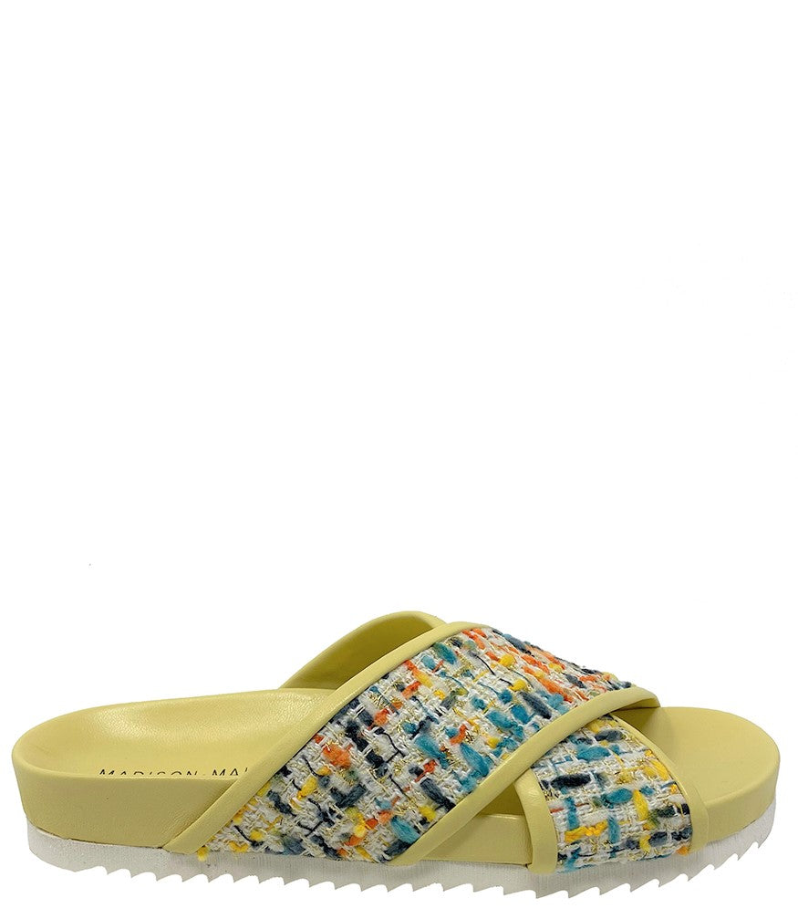 A handcrafted Italian open-toe flat sandal featuring a wide strap with a centered oval gemstone surrounded by circular studs, set on a molded footbed with a low platform sole."