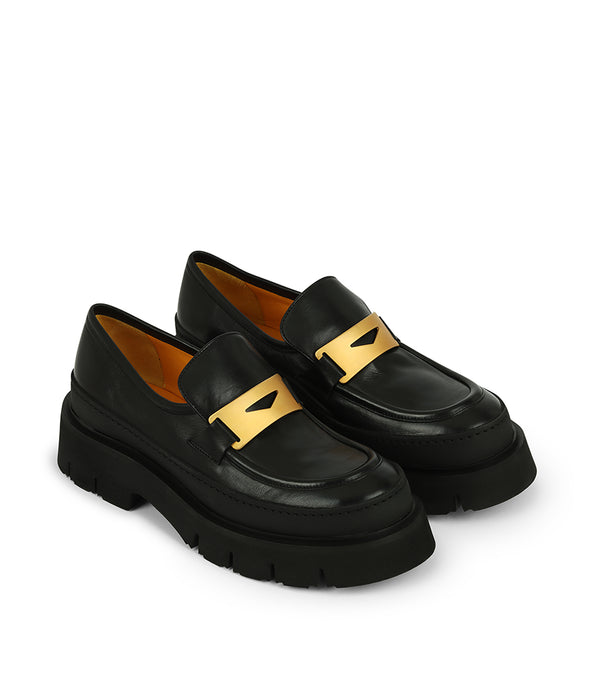 A leather loafer with an exaggerated lug sole and low-cut silhouette, featuring a wide strap with a geometric metal detail across the upper. Designed by Madison in Beverly Hills and handcrafted in Italy.