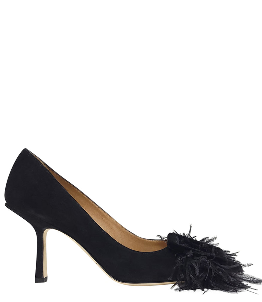Pointed-toe pump crafted from soft suede with a mid-height stiletto heel, featuring a dramatic feather and velvet buckle embellishment across the toe. Designed with a leather-lined interior and a durable leather outsole for lasting comfort and support. El